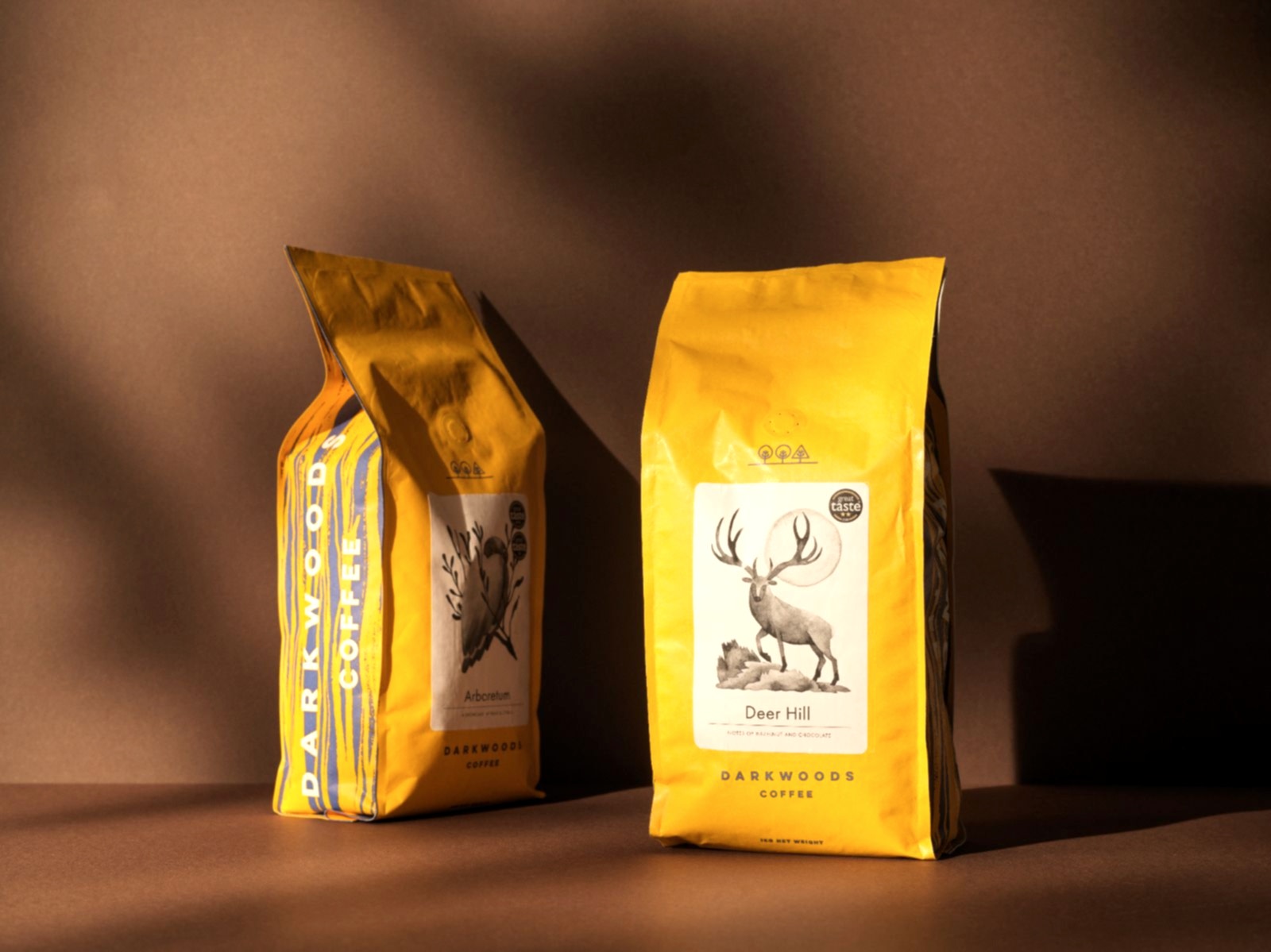 93 branding for Dark woods wholesale coffee. Two yellow bags with an owl and stag motif. Great Taste award sticker on bag. 