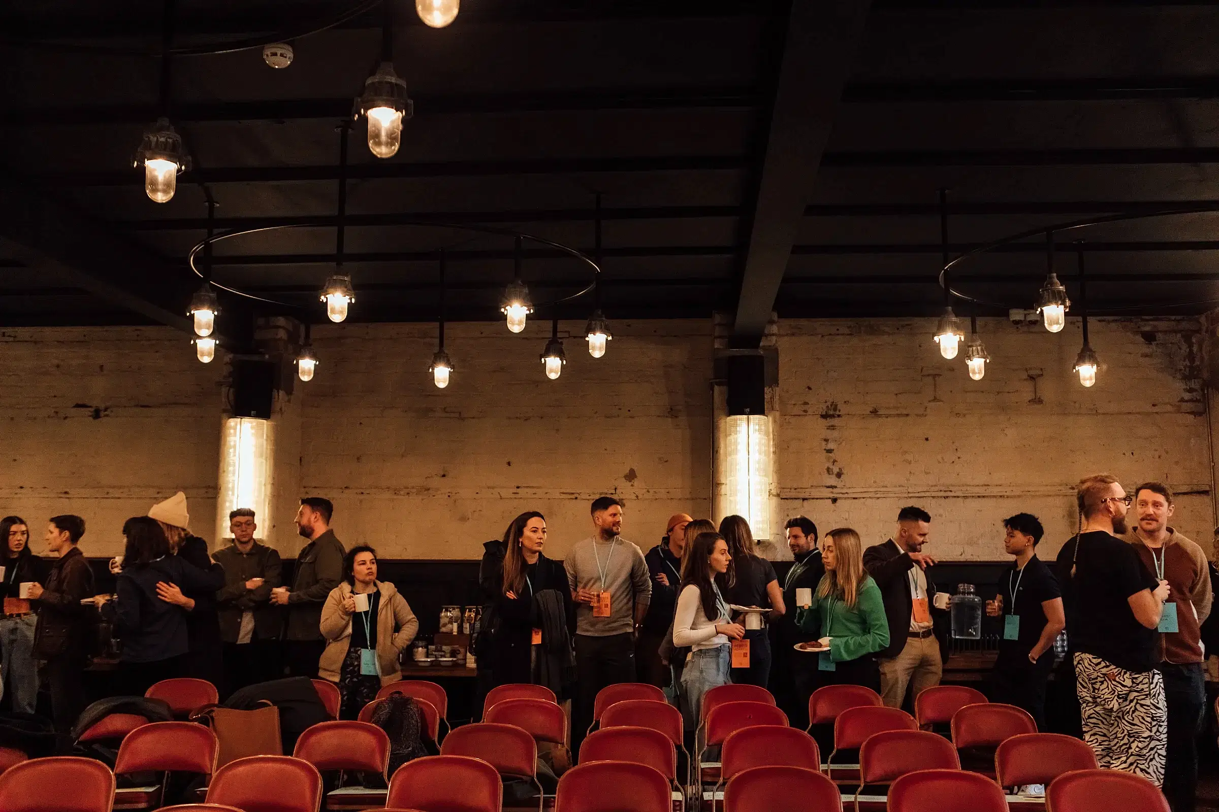 A crowd of the attendees talking and networking in The Mowbray space.