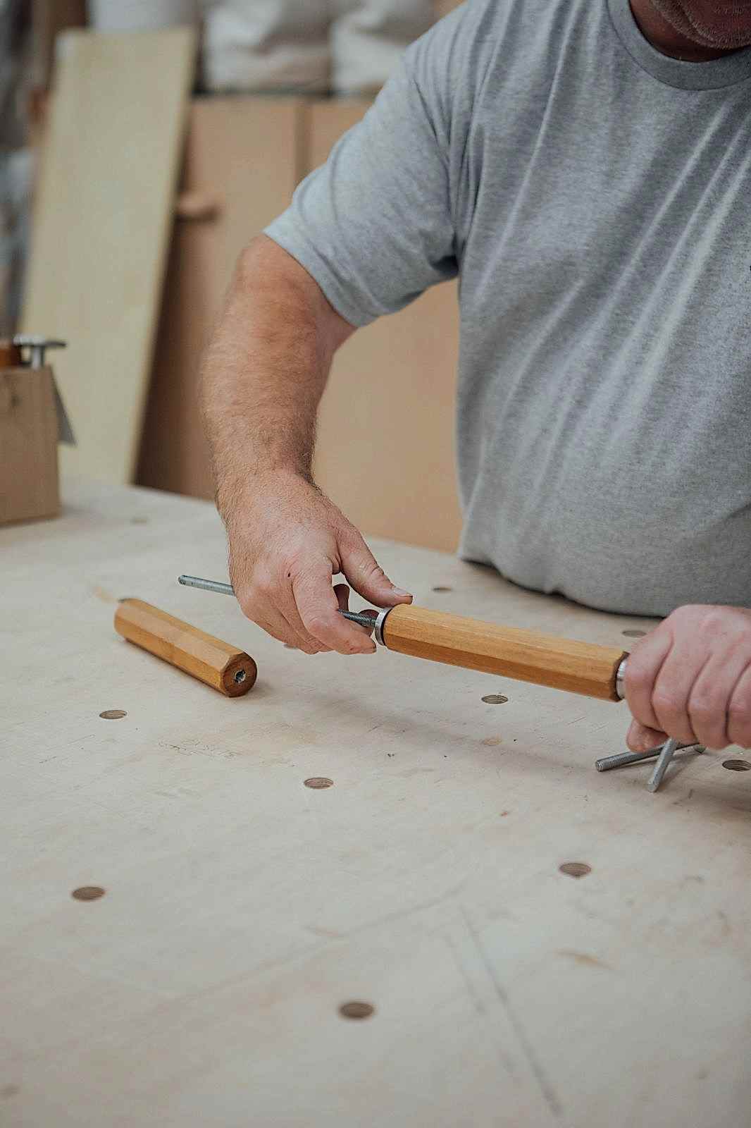 Assembling a commissioned door handle for Kangaroo Works Sheffield by threading three octagonal handles on a steel pole.