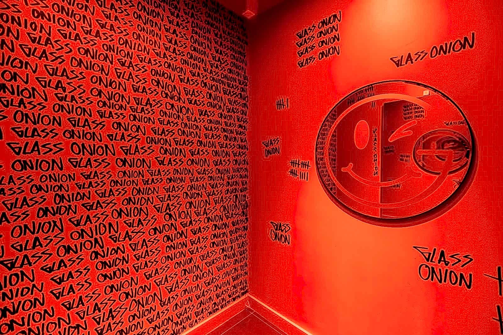 Red changing room with circular mirror with smiley face design 