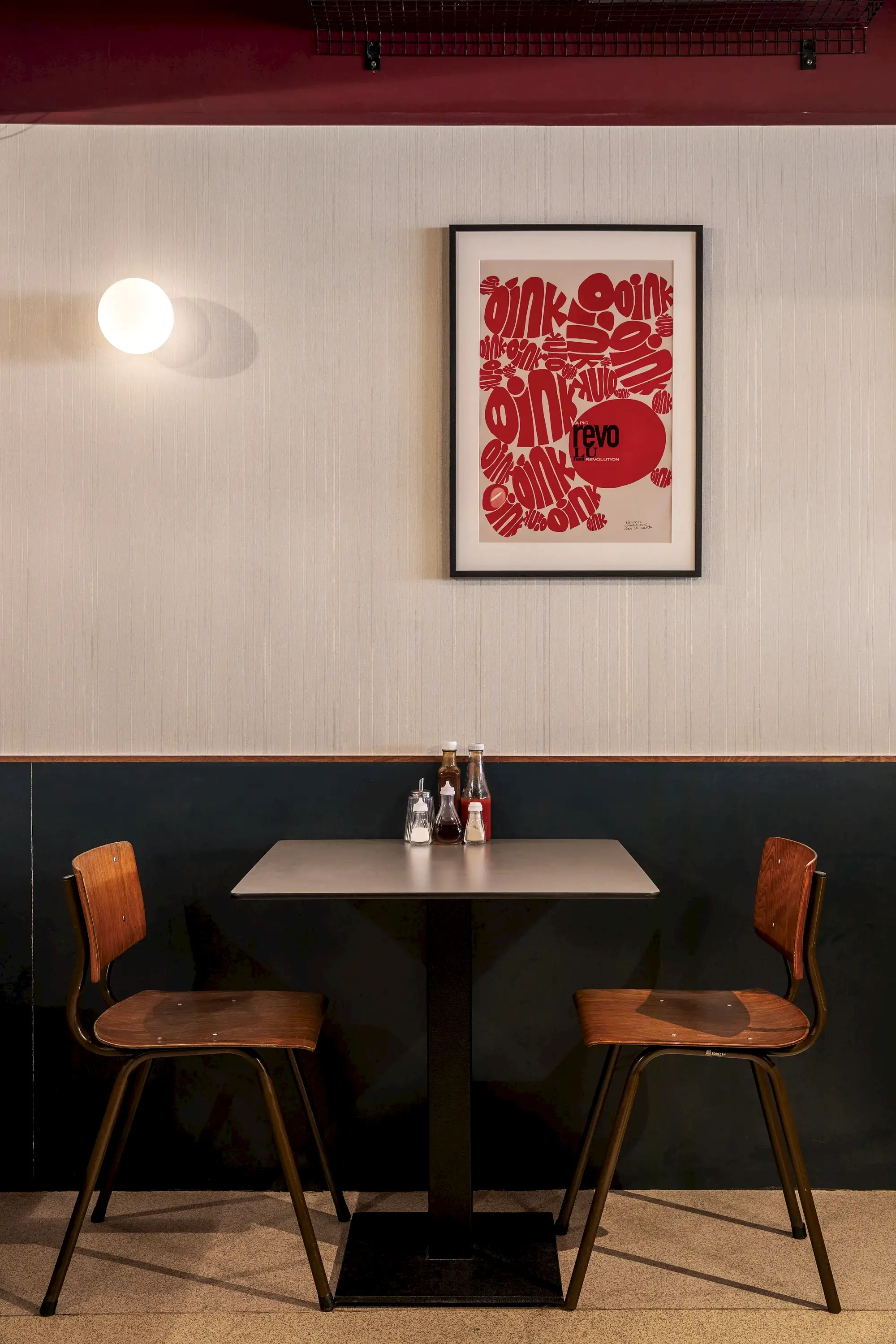 Vintage, reclaimed tables and chairs seating arrangement, with artwork framed on the wall above.