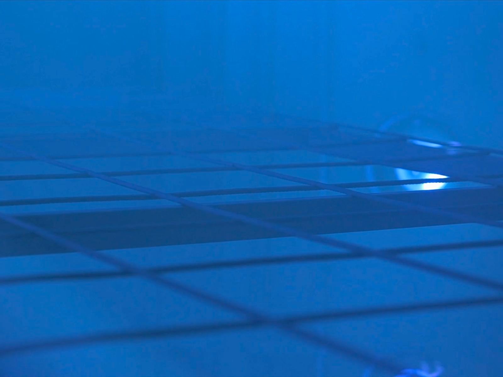 Close up of metal grid inside the Parla Physical Vapour Deposition machine - blue lighting.