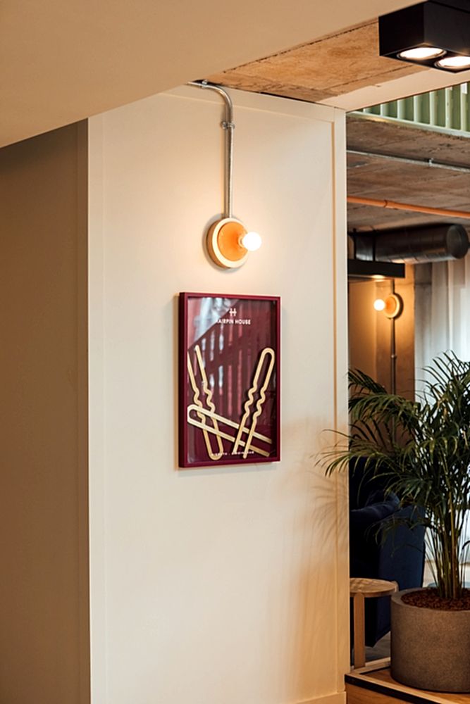 Inside BTR Hairpin House, Birmingham. Three brass hair pins mounted inside a burgundy frame. Sleek interior design. 