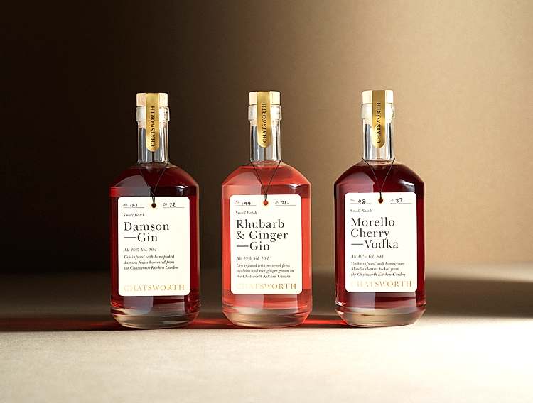 Warmly-lit, beige backdrop. 3 Chatsworth drinks bottles with pink liquid: DAMSON GIN, RHUBARB GIN, MORELLO CHERRY VODKA. 